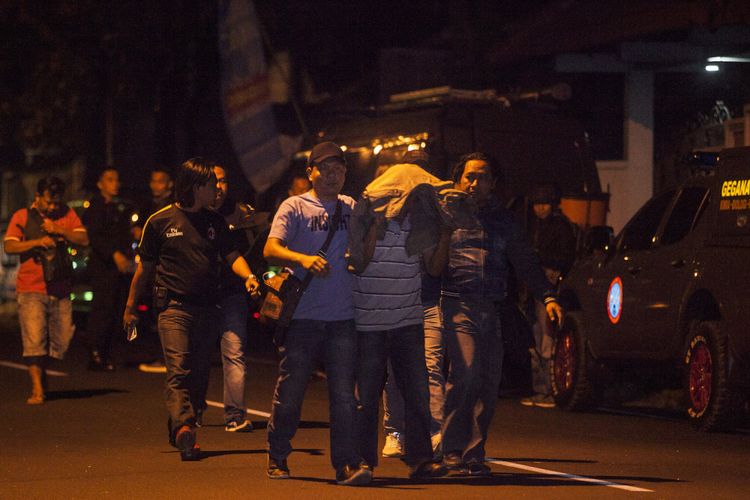 Polisi mengamankan seseorang saat penangkapan terduga teroris di Jl. Kaliurang, Ngaglik, Sleman, DI Yogyakarta, Sabtu (14/7). Dalam penangkapan itu polisi menembak tiga terduga teroris dan hingga saat ini polisi masih melakukan penyelidikan terkait penangkapan tersebut. ANTARA FOTO/Andreas Fitri Atmoko/nz/18.  