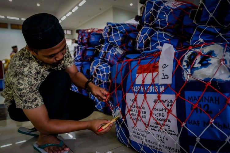 Petugas memberi tanda pada barang bawaan calon jemaah haji Kelompok Terbang (Kloter) 6 di Asrama Haji Pondok Gede, Jakarta, Rabu (18/7/2018). Sebanyak 24.524 calon jemaah haji dan 315 petugas akan diberangkatkan dari Asrama Haji embarkasi Jakarta.