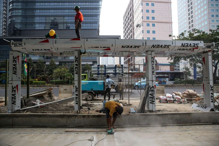 Pekerja menyelesaikan revitalisasi trotoar dan taman di kawasan jalan Sudirman, Jakarta Pusat, Kamis (19/7/2018). Penataan trotoar dan taman ditargetkan selesai pada akhir bulan Juli sebelum pelaksanaan Asian Games 2018.