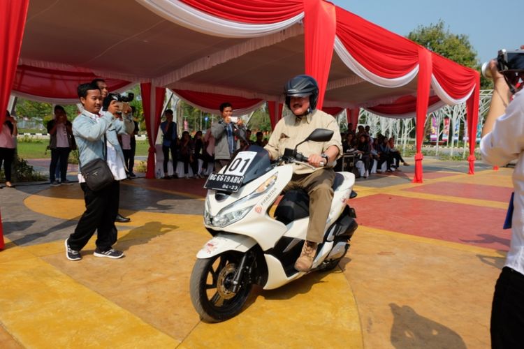 Gubernur Sumatera Selatan Alex Noerdin menjajal Honda PCX saat acara penyerahan 50 unit Honda PCX dari Astra Motor Sumsel kepada panitia penyelenggara Asian Games 2018 Palembang, di Jakabaring Sport City, Senin (23/7/2018). Secara simbolis, penyerahan dilakukan oleh Kepala Wilayah Astra Motor Sumsel, Ronny Asgustinus.