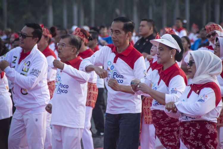 Presiden Joko Widodo (tengah) bersama Ibu Negara Iriana Joko Widodo (kedua kanan) dan Wakil Presiden Jusuf Kalla (kedua kiri) beserta istri Mufidah Jusuf Kalla (kanan) menari ketika mengikuti pemecahan rekor dunia atau Guinness World Record (GWR) Tari Poco-Poco 2018 di Monumen Nasional (Monas), Minggu (5/8/2018). Kegiatan dalam rangka menyambut Asian Games 2018 itu diikuti 65 ribu peserta dari berbagai kalangan.