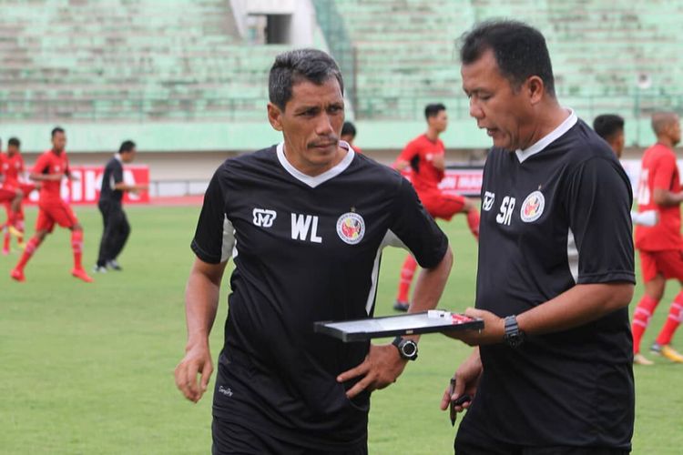 Pelatih kepala Semen Padang Syafrianto Rusli sedang berdiskusi dengan asistenya Weliansyah
