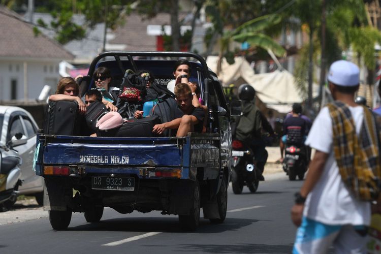 Sejumlah wisatawan mancanegara menumpang mobil bak terbuka ketika menuju Mataram di Lombok Utara, NTB, Senin (6/8/2018). Sedikitnya 700 orang wisatawan bersama warga setempat dievakuasi dari Gili Trawangan, Gili Air dan Gili Meno menuju Pelabuhan Bangsal mengantisipasi terjadinya gempa susulan.