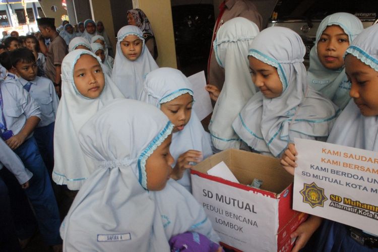 Para siswa SD Mutual Kota Magelang, Jawa Tengah, menggalang dana untuk disumbangkan kepada korban gempa di Lombok, NTB, Selasa (7/8/2018).