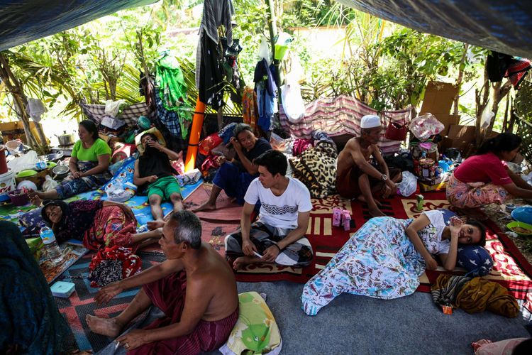 Pengungsi beristirahat dalam tenda darurat di lapangan Menggala, Desa Menggala, Kecamatan Pemenang, Lombok Utara, NTB, Rabu (8/8/2018).