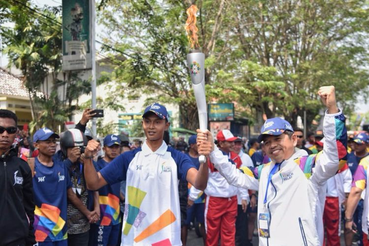 Ketua KONI Kabupaten Purwakarta Dedi Mulyadi saat menerima obor Asian Games dari seorang pelari di Purwakarta, Jawa Barat, Jumat (10/8/2018).