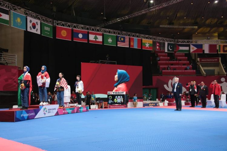 Taekwondoin putri Indonesia, Defia Rosmaniar, ketika menyanyikan lagu Indonesia Raya seusai meraih medali emas Asian Games 2018  pada nomor poomsae individu putri di Plenary Hall JCC, Jakarta, Minggu (19/8/2018).