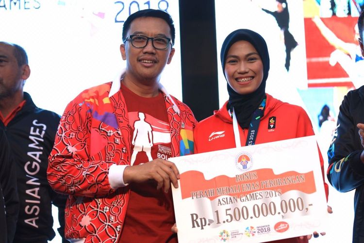 Menpora Imam Nahrawi menyerahkan secara simbolis bonus kepada atlet peraih medali emas Asian Games 2018, Defia Rosmaniar, di Kemenpora, 20 Agustus 2018. 