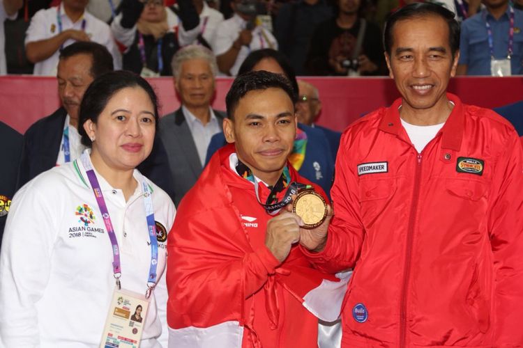 Menko PMK Puan Maharani berfoto bersama lifter Indonesia Eko Yuli Triawan dan Presiden Jokowi (kiri-kanan). Eko berhasil meraih medali emas di cabor angkat besi kelas 62 kilogram di JIExpo Kemayoran, Selasa (21/8/2018).