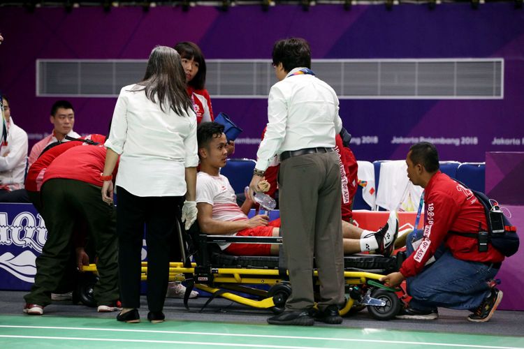 Pemain bulu tangkis tunggal putra Indonesia, Anthony Sinisuka Ginting cedera saat bertanding melawan pemain tunggal putra China Shi Yuqi pada pertandingan final beregu putra Asian Games 2018 di Istora Senayan, Jakarta, Rabu (22/8/2018).