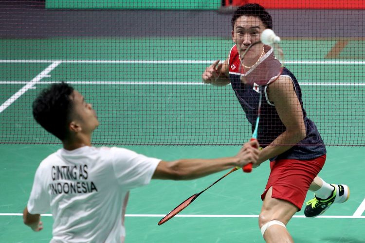 Pebulu tangkis putra Indonesia Anthony Sinisuka Ginting (kiri) berupaya mengembalikan kok ke arah lawannya pebulu tangkis putra Jepang Kento Momota (kanan), pada pertandingan babak semifinal beregu putra Asian Games 2018 di Istora Senayan, Jakarta, Selasa, (20/8/2018).  - INASGOC