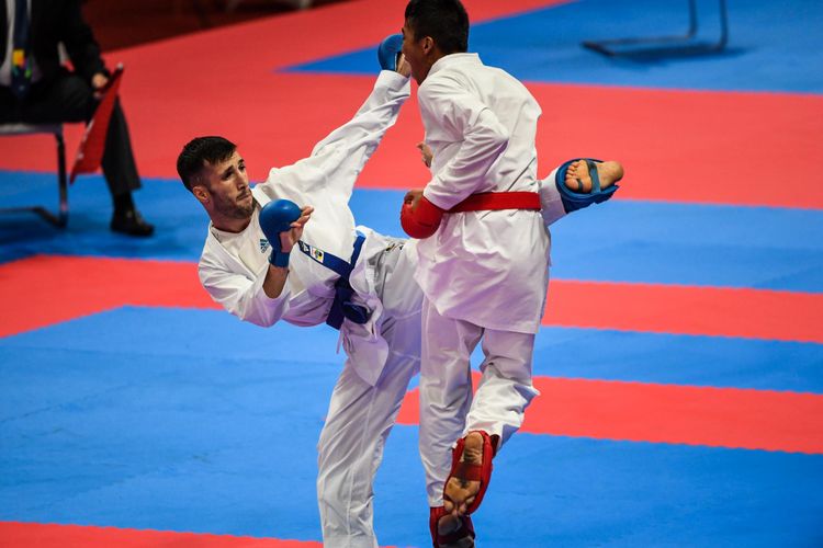 Karateka Indonesia, Rifki Ardiansyah Arrosyiid (sabuk merah) melakukan serangan ke karateka Iran, Mahdi Zadeh Amir (sabuk biru) di Gedung JCC Plenary Hall, Jakarta Pusat, Minggu (26/8/2018). Rifki Ardiansyah Arrosyiid menang atas karateka Iran, Mahdi Zadeh Amir dengan skor 9-7 dan meraih medali Emas.