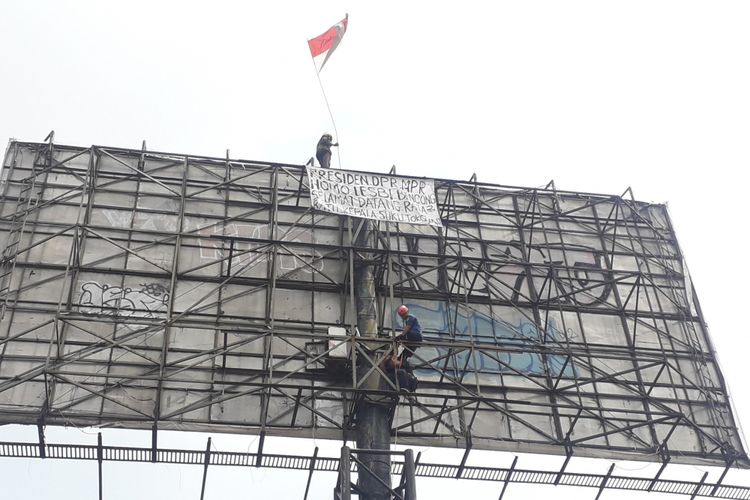 Evakuasi pria yang naiki papan reklame berjalan alot, Pasar Rebo, Rabu (12/9/2018)