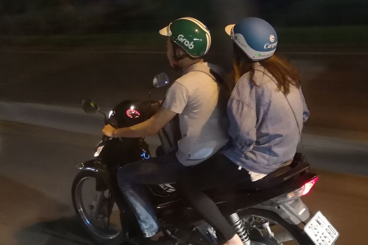 Driver Grab mengantar pelanggan di kota Hanoi, Vietnam.