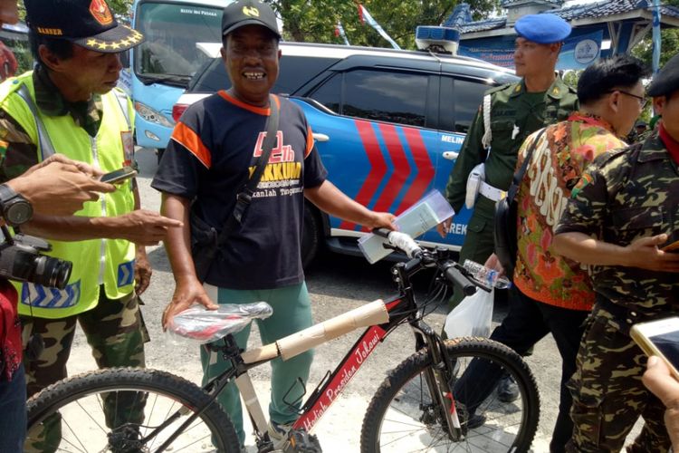 ‎Purwanto (53), warga Desa Jangkungharjo, Kecamatan Brati, Grobogan, Jateng, menuntun sepeda pemberian Presiden Jokowi ‎di Stadion Krida Bhakti, Kecamatan Purwodadi, Sabtu (15/9/2018).