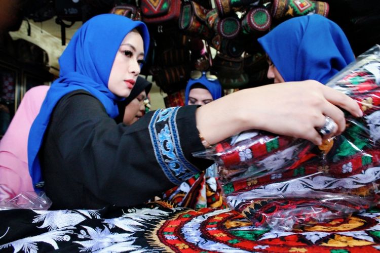Siti Ruby Aliya Rajasa (Aliya) saat memperhatikan ukiran kerawang Gayo yang terbordir di Upuh Ulen-ulen, kain khas Gayo yang diproduksi oleh para pengusaha kerajinan kerawang Gayo di kawasan ekonomi kreatif, di Kampung Bebesen, Kabupaten Aceh Tengah.