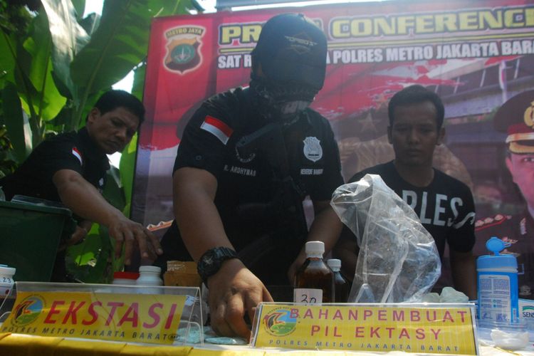 Sejumlah petugas sedang menyiapkan barang bukti hasil pengungkapan penggerebekan rumah yang dijadikan pabrik ekstasi di Perumahan Sentra Pondok Rajeg, Cibinong, Bogor, Jawa Barat, Senin (24/9/2018).