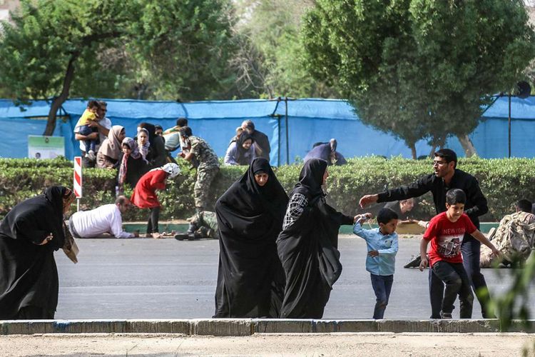 Seorang pria membantu wanita dan anak-anak ketika mencoba melarikan diri saat terjadinya serangan pada parade militer di Kota Ahvaz, Iran, Sabtu (22/9/2018). Serangan yang terjadi pada parade militer Iran untuk memperingati dimulainya perang 1980-1988 dengan Irak yang kala itu dipimpin Saddam Hussein tersebut menewaskan 29 orang dan membuat 57 orang lainnya terluka.