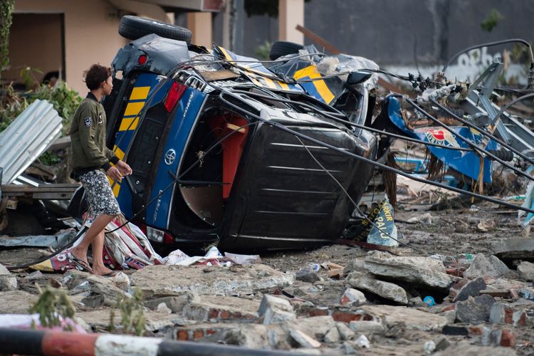 Seorang lelaki mencari barang-barang dari rumahnya yang rusak di Palu, Sulawesi Tengah, Sabtu (29/9/2018), setelah gempa kuat dan tsunami melanda daerah itu sehari sebelumnya. Hampir 400 orang tewas ketika gempa dan tsunami di Kota Palu.