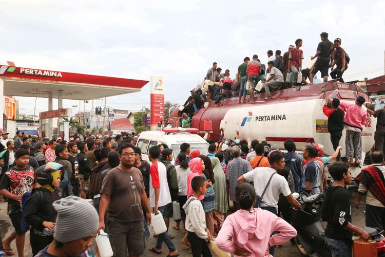 Warga menjarah baan bakar minyak di SPBU Jalan Imam Bonjo, Kota Palu, Sulawesi Tengah, Minggu (30/9/2018) pasca gempa bumi yang melanda kota tersebut. Selain mengakibatkan kelangkaan BBM, gempa Palu juga mengakibatkan ribuan bangunan rusak dan sedikitnya 420 orang meninggal dunia.