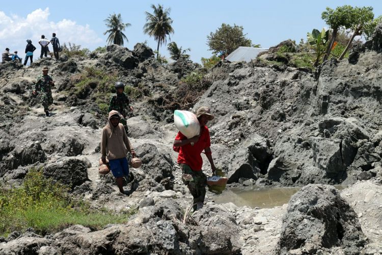 Warga Kelurahan Petobo, Kecamatan Palu Selatan, Kota Palu, Sulawesi Tengah, mengangkuti barang yang masih bisa diselamatkan dari rumah-rumah mereka yang terendam lumpur yang keluar dari perut bumi pasca-gempa bermagnitudo 7,4.. Kompas.com