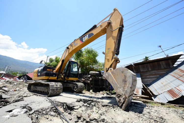 Ekskavator dikerahkan untuk membersihkan puing-puing di Perumahan Perumnas Balaroa, Senin (1/10/2018).