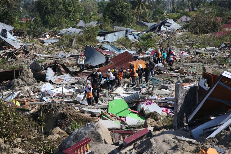 Warga dibantu petugas mencari korban gempa bumi Palu di Perumnas Balaroa, Palu, Sulawesi Tengah, Senin (1/10/2018). Gempa bumi dan tsunami di Palu dan Donggala, Sulawesi Tengah mengakibatkan 832 orang meninggal.