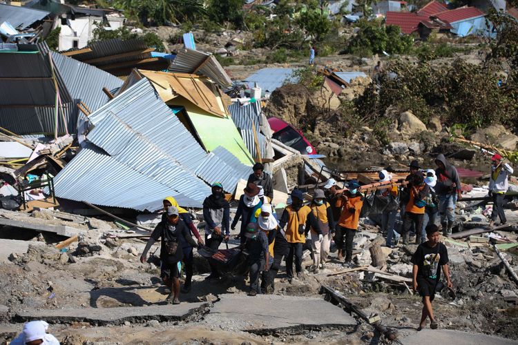 Warga dibantu petugas mencari korban gempa bumi Palu di Perumnas Balaroa, Palu, Sulawesi Tengah, Senin (1/10/2018). Gempa bumi dan tsunami di Palu dan Donggala, Sulawesi Tengah mengakibatkan 832 orang meninggal.