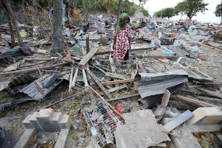 Moda membersihkan makam orang tuanya di Desa Loli Saluran, Kecamatan Banawa, Kabupaten Donggala, Sulawesi Tengah, pasca gempa dan Tsunami, Rabu (3/10/2018). Gempa yang terjadi di Palu dan Donggala mengakibatkan 925 orang meninggal dunia dan 65.733 bangunan rusak.