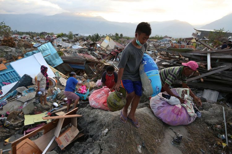 Warga korban gempa bumi menyelamatkan barang berharga yang masih bisa digunakan di Petobo, Palu, Sulawesi Tengah, Jumat (5/10/2018). Petobo menjadi salah satu wilayah yang paling parah terdampak gempa karena dilalui sesar Palu Koro.
