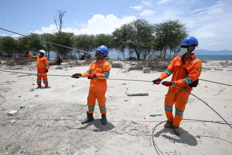 Petugas memperbaiki jaringan listrik di Jalan Trans Sulawesi di Mamboro, Kecamatan Palu Utara, Palu, Sulawesi Tengah, yang putus akibat gempa dan tsunami, Sabtu (6/10/2018). Jaringan listrik di beberapa wilayah di Kota Palu sudah mulai menyala.