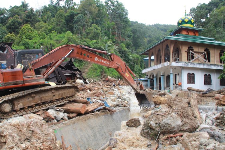 Petugas menggunakan alat berat berusaha menggeser batu yang terbawa arus sungai pascabanjir bandang yang terjadi, di Desa Muara Saladi, Kecamatan Ulu Pungkut, Mandailing Natal, Sumatera Utara, Sabtu (13/10). Banjir bandang yang terjadi pada Jumat (12/10) melanda sembilan kecamatan di Kabupaten Mandailing Natal. Peristiwa itu menyebabkan sedikitnya 13 orang meninggal dunia dan 10 orang lainnya dinyatakan hilang. ANTARA FOTO/Holik Mandailing/im/kye/18.