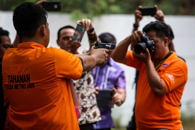 Kepolisian melakukan rekonstruksi kasus peluru nyasar di Gedung DPR RI di Lapangan Tembak Senayan, Gelora, Tanah Abang, Jakarta Pusat, Jumat (19/10/2018). Diberitakan sebelumnya, polisi menetapkan I (32) dan R (34) sebagai tersangka dalam kasus ini. Mereka ditangkap usai berlatih menembak di lapangan tembak Senayan pada Senin (15/10/2018).