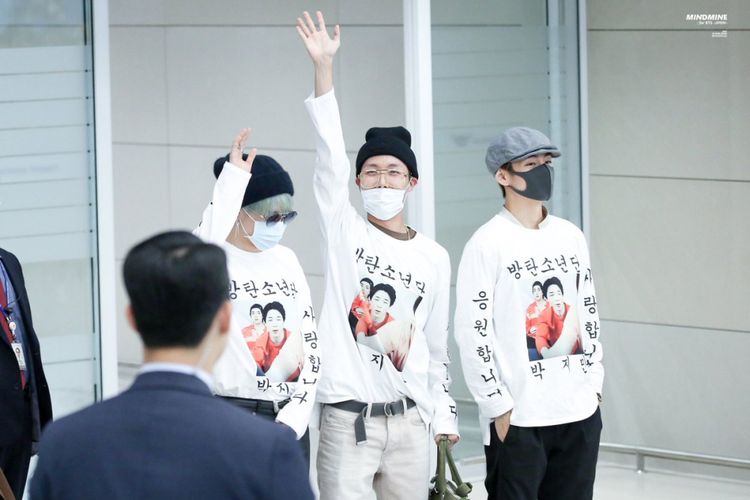 Tiga member BTS, (dari kiri) Jimin, J-Hope, dan V memamerkan kaus istimewa saat tiba di Bandara Incheon, Seoul, Korea Selatan, Rabu (24/10/2018).