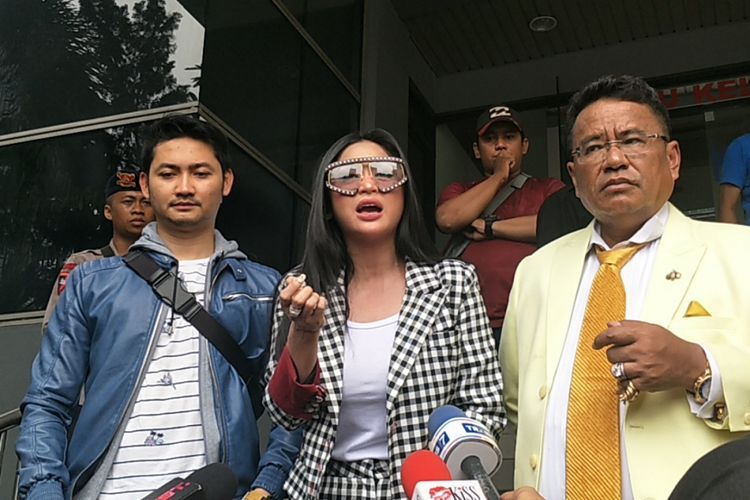 Dewi Perssik didampingi suaminya, Angga Wijaya (kiri), dan kuasa hukumnya, Hotman Paris (kanan), melaporkan keponakannya, Rosa Meldianti, ke Polda Metro Jaya, Jakarta Selatan, Senin (5/11/2018).