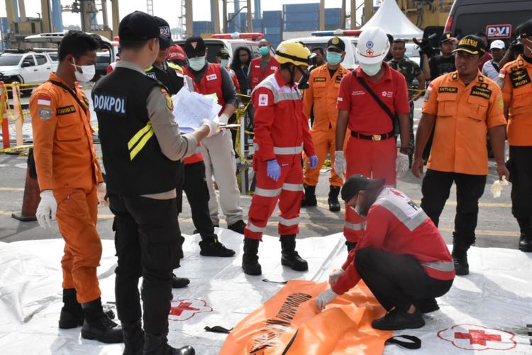 Petugas memeriksa satu kantong jenazah yang tiba di Dermaga JICT 2 Pelabuhan Tanjung Priok, Jumat (9/11/2018).