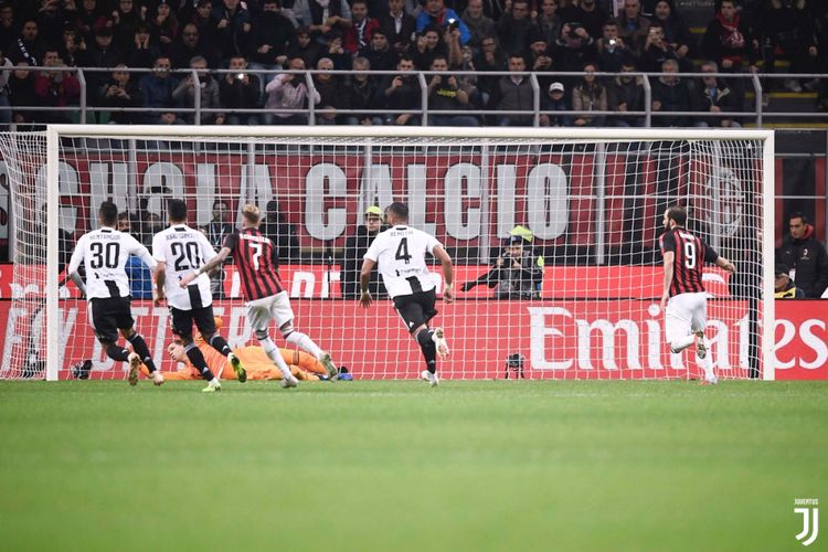 Penjaga gawang Juventus, Wojciech Szczesny, menepis bola eksekusi penalti Gonzalo Higuain (kanan) saat Juventus menang 2-0 atas AC Milan dalam pertandingan Serie A di San Siro, Minggu (11/11/2018).