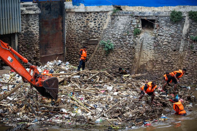 Petugas UPK Badan Air membersihkan tumpukan sampah di Pintu Air Manggarai, Jakarta, Selasa (13/11/2018). Aneka jenis sampah itu terbawa aliran Sungai Ciliwung. Sampah-sampah itu diperkirakan akan terus ada saat debit air Ciliwung tinggi, terutama saat daerah Bogor dan sekitarnya diguyur hujan deras.