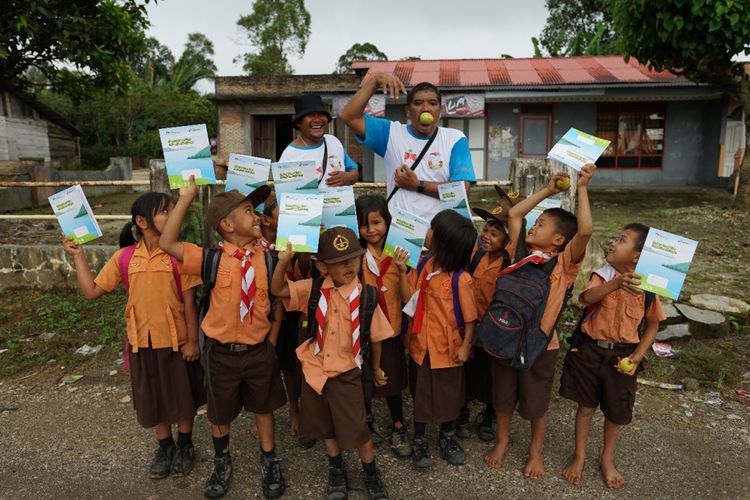 Togu Simorangkir bersama Biston Hutahuruk, saat membagikan buku tulis kepada murid sekolaj dasar.