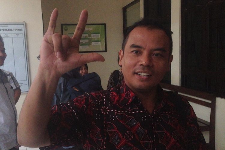 Salam metal tiga jari dilakukan Bupati Purbalingga nonaktif yang menjadi terdakwa suap dan gratifikasi, Tasdi, di Pengadilan Tipikor Semarang, Rabu (28/11/2018).