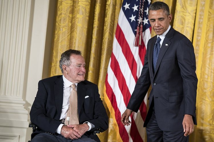 Mantan Presiden Amerika Serikat George HW Bush bersama Presiden aktif AS Barack Obama saat menghadiri acara di East Room, Gedung Putih, pada 15 Juli 2013. George Bush Senior meninggal Jumat (30/11/2018) dalam usia 94 tahun.