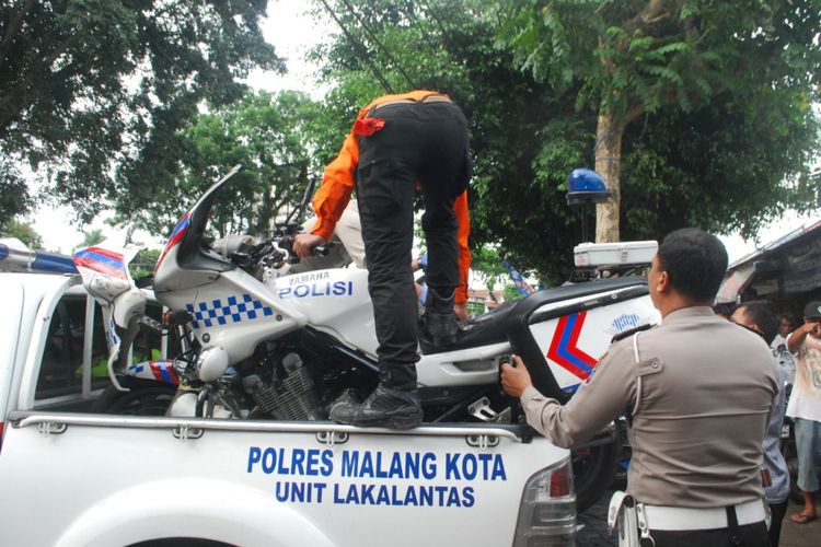 Anggota Satlantas Polres Malang Kota saat mengevakuasi motor patwal anggota Satlantas Polres Mojokerto yang mengalami kecelakaan, Minggu (16/12/2018)
