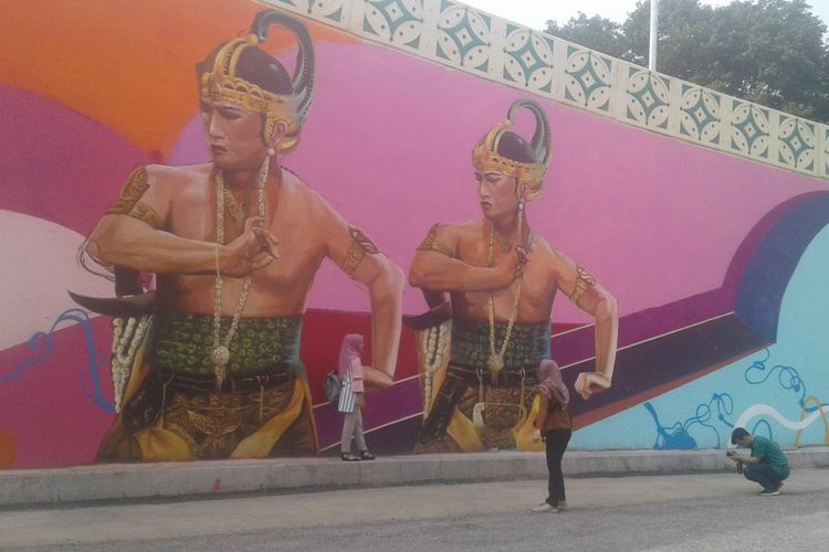 Pengunjung saat berfoto di dinding flyover Manahan yang dihiasi mural Pandawa, Senin (17/12/2018).
