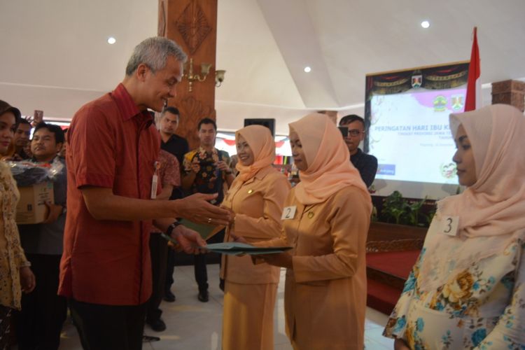 Gubernur Jawa Tengah, Ganjar Pranowo menyerahkan sejumlah bantuan dan penghargaan kepada perwakilan penerima, di sela peringatan Hari Ibu yang dipusatkan di Pendopo Pengabdian Rumah Dinas Walikota Magelang, Selasa (18/12/2018).