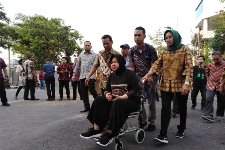 Wali Kota Surabaya, Tri Rismaharini, saat meninjau lokasi amblesnya Jalan Raya Gubeng, Surabaya, untuk kedua kalinya, Kamis (20/12/2018). Risma harus menggunakan kursi roda karena mengalami cedera kaki.