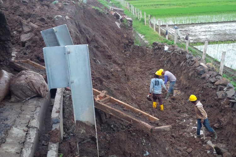 Para pekerja sedang memperbaiki lereng Jalan Tol ruas Salatiga-Kartasura di KM 489+500 yang rusak akibat tergerus air hujan, Rabu (26/12/2018).
