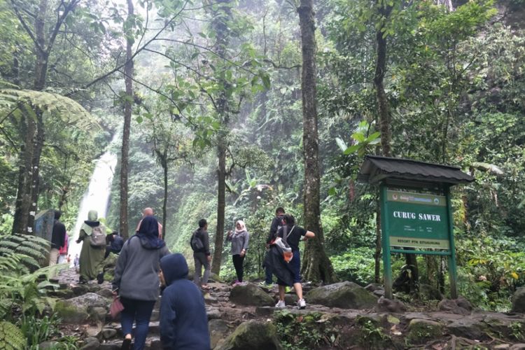 Pengunjung berfoto di dekat Curug Sawer yang terletak di dalam kawasan wisata Situ Gunung, Sukabumi, Jawa Barat.