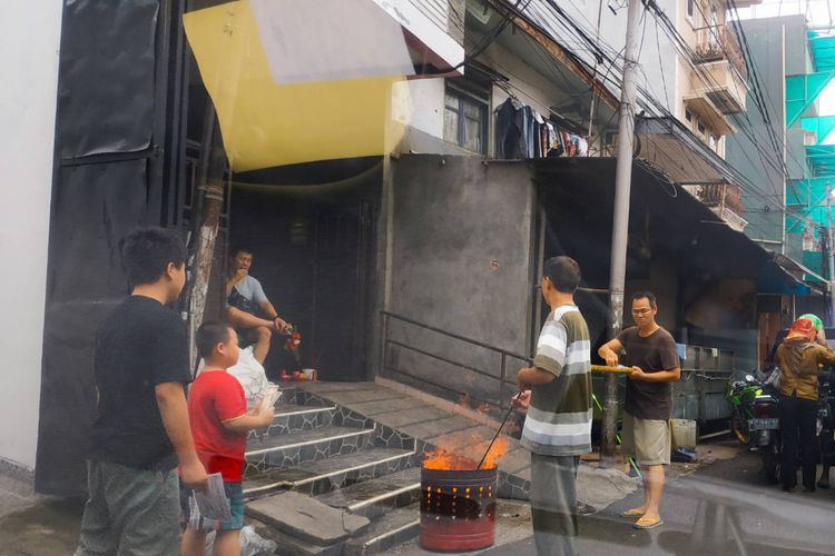 Beberapa anggota keluarga Tionghoa di kawasan Petak Sembilan, Jakarta Barat, tengah membakar uang akhirat bagi para leluhur.