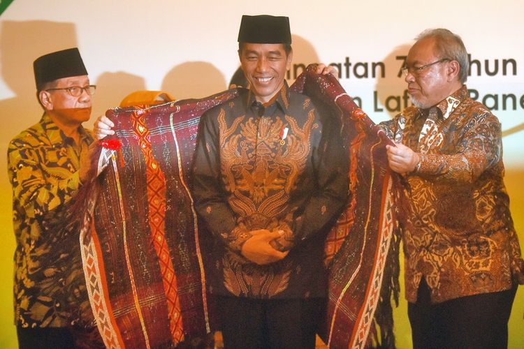 Presiden Joko Widodo (tengah) menerima penyematan kain ulos oleh Ketua Dewan Penasihat Himpunan Mahasiswa Islam (HMI) Akbar Tandjung (kiri) dan anak pendiri HMI Lafran Pane, Iqbal Pane (kanan) saat Peringatan 72 tahun HMI dan syukuran pengangkatan Lafran Pane sebagai pahlawan nasional di Jakarta, Selasa (5/2/2019). ANTARA FOTO/Akbar Nugroho Gumay/ama.