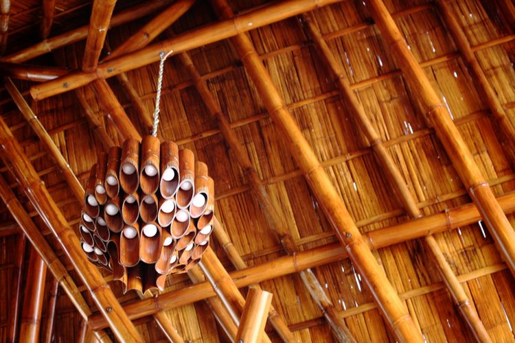 Atap gedung dibangun dari struktur bambu utuh yang menjulang.
